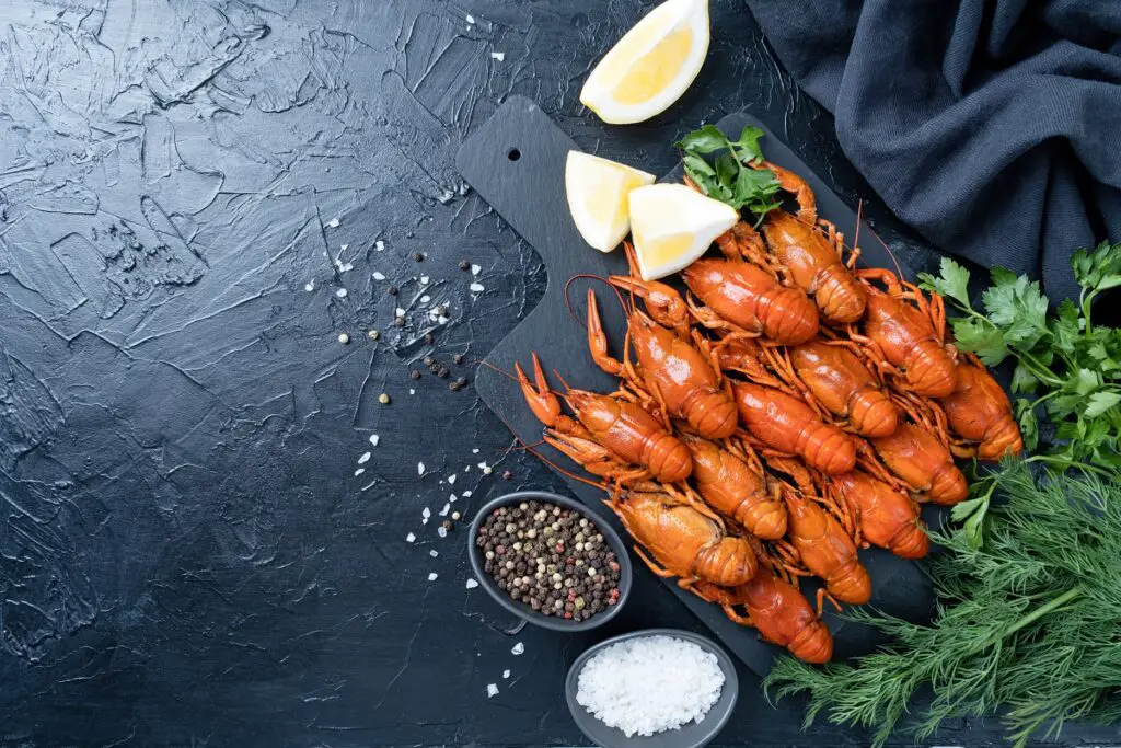 cooked crawfish on platter with lemons and spices